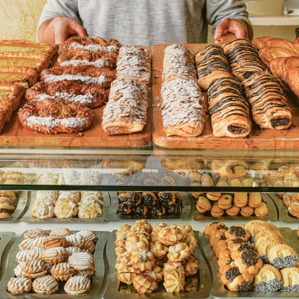 an assortment of pastries are placed above a glass shelf with tea cookies